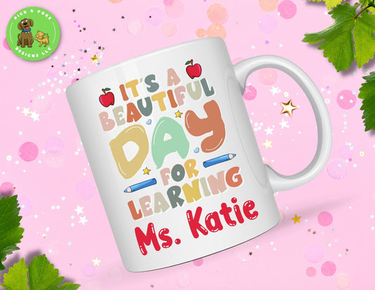 White 11oz ceramic mug with the quote "It's a beautiful day for learning" and name personalization. 