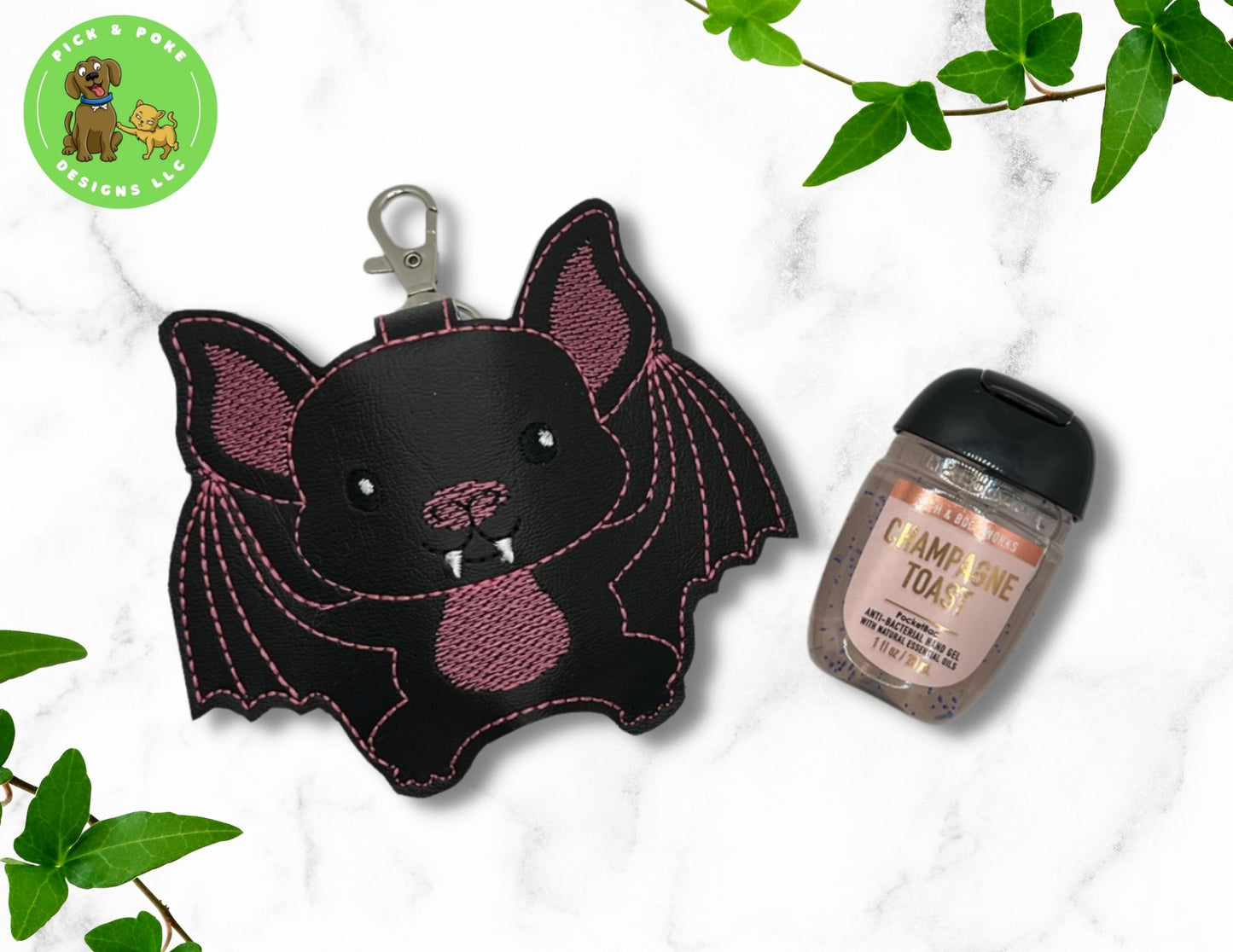 Vinyl hand saniziter holder in the shape of  cartoon bat with pink stitching and lobster clasp style key ring. 