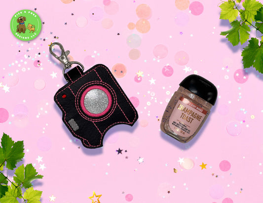 Custom hand sanitizer holder keychain shaped like a retro camera that holds one ounce bottle 
